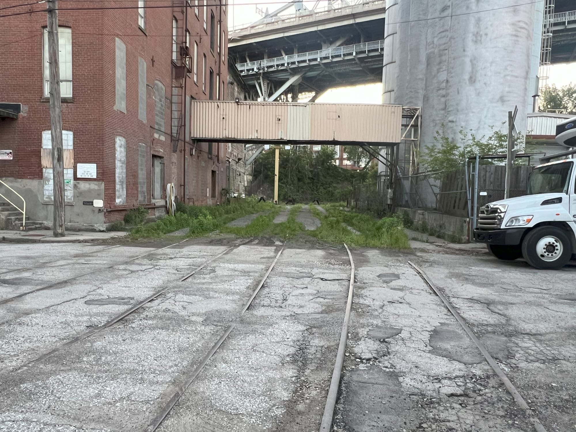 3 parallel train right of ways heading to under a grain silo. 